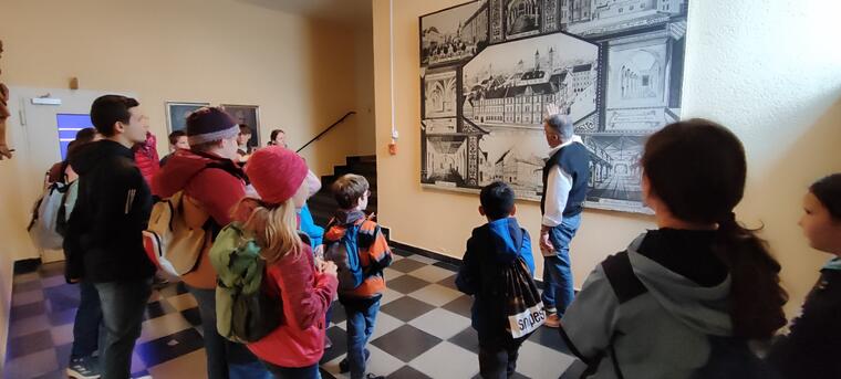 Kinder sitzen in einer blau erleuchteten Kapelle.